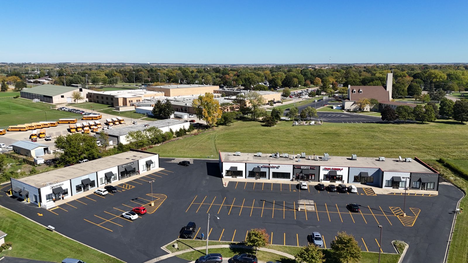 Aerial of a suburban multi-tenant retail center with parking